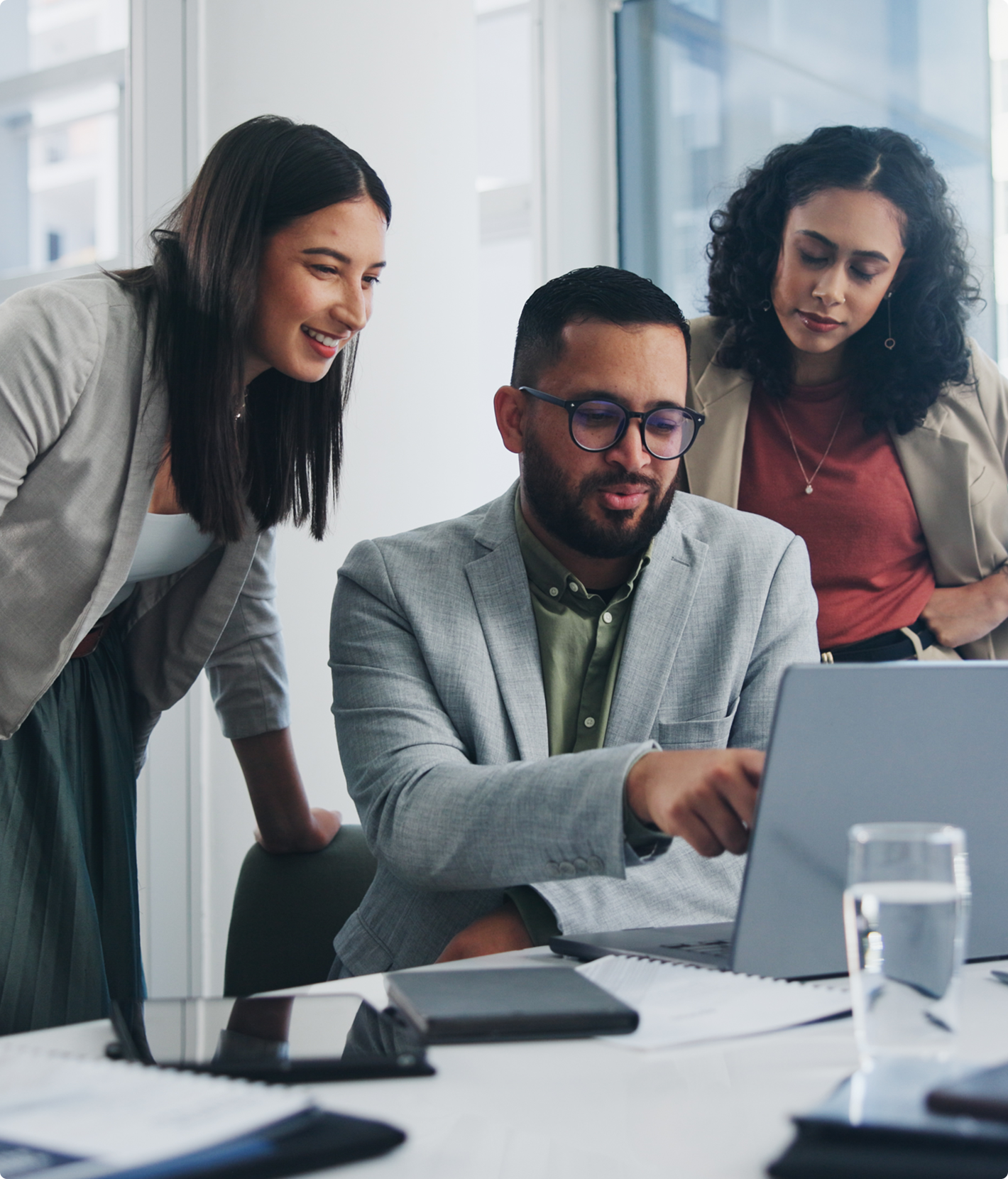 Three colleagues collaborating over a laptop.