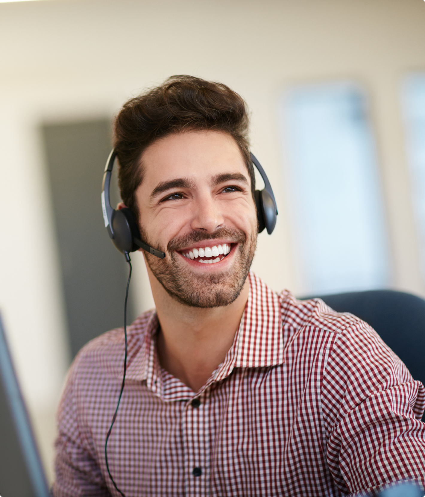 Smiling man wearing headset in office setting.