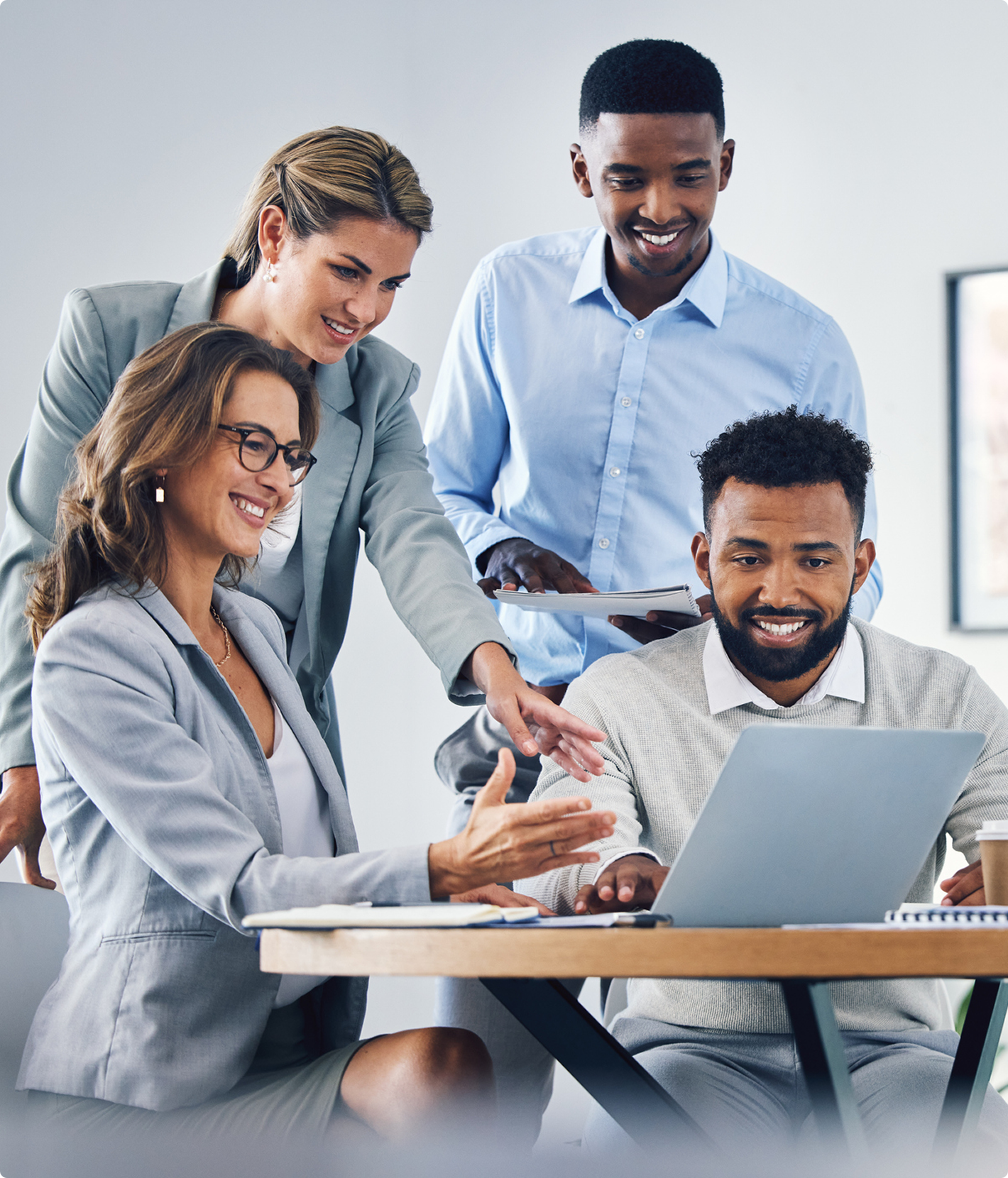 Team collaborating around a laptop happily.