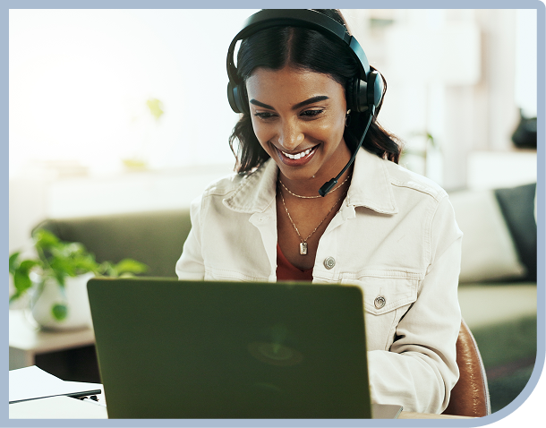 Person smiling while using a laptop headset.